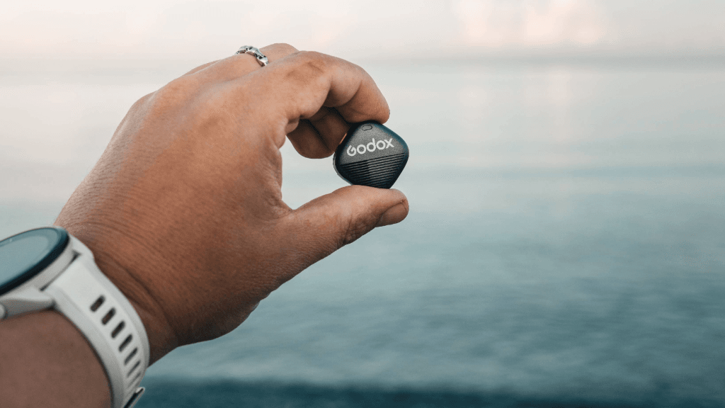 Close-up van de Godox Cube-S draadloze microfoon in de hand van een content creator.