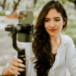 Content creator maakt een vlog met smartphone en gimbal in een park